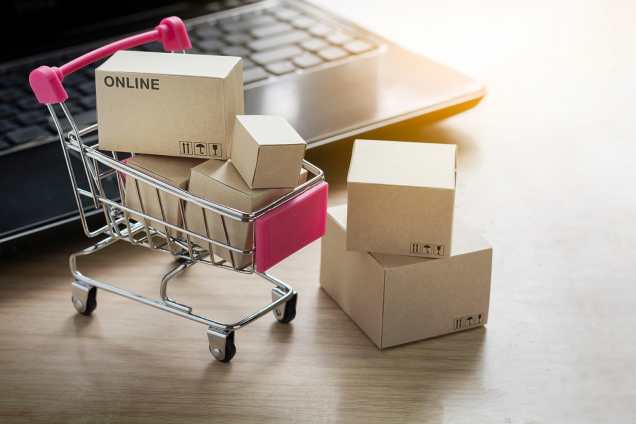 small boxes in a miniature shopping cart. Photo. 