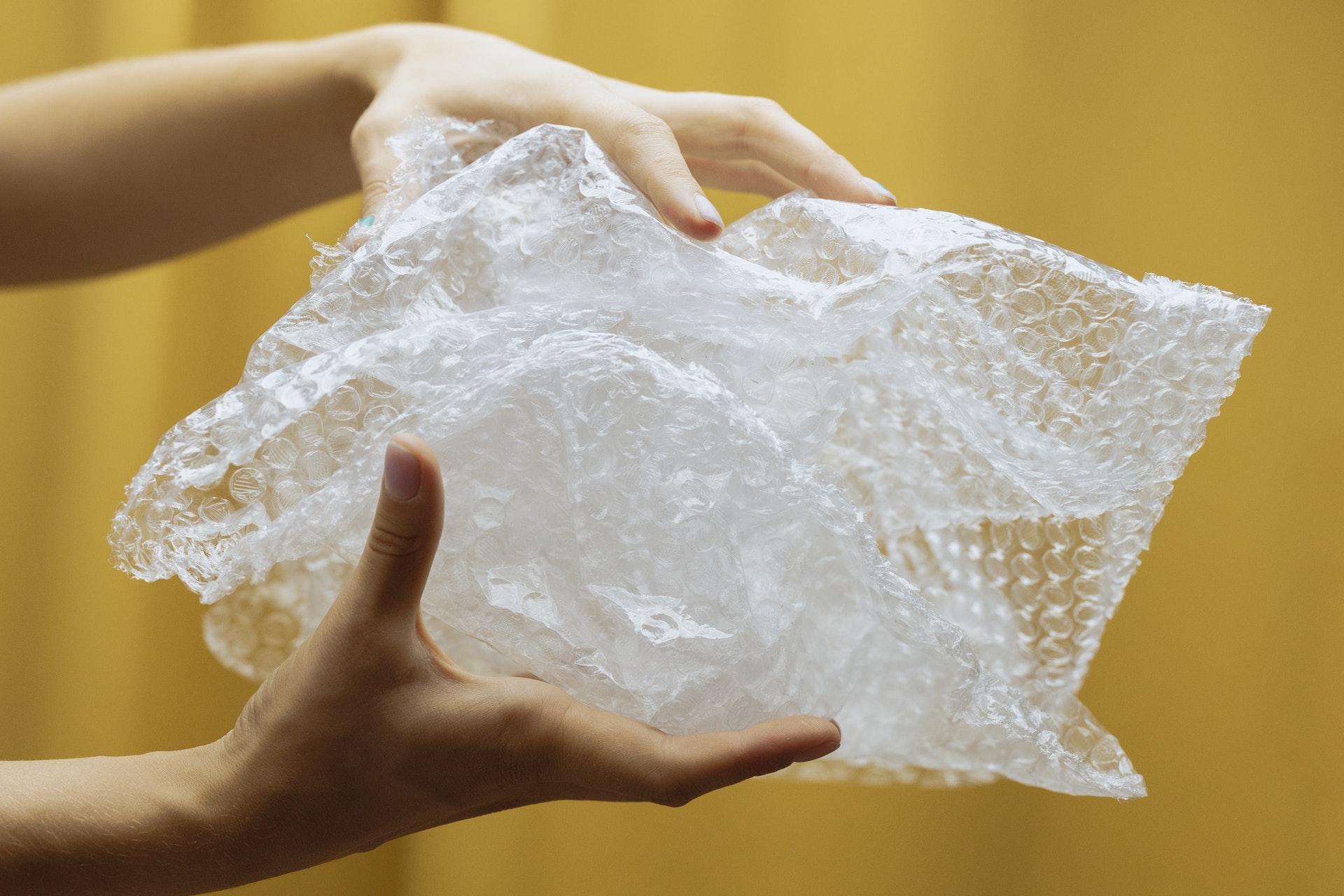 two hands holding a bag of bubble wrap. Photo. 